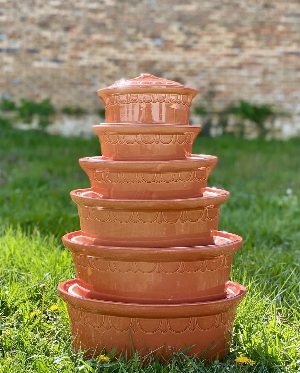 Pile de terrines rondes en terre cuite, de la plus grande à la plus petite